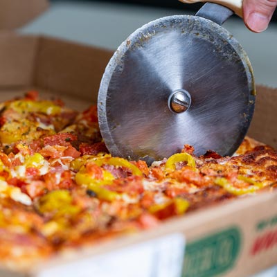 Zoomed in shot of a pizza being cut